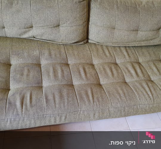 ספה ירוקה עם ריפוד מרופד על רצפת אריחים